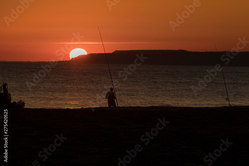 fishermen on the beach at sunset