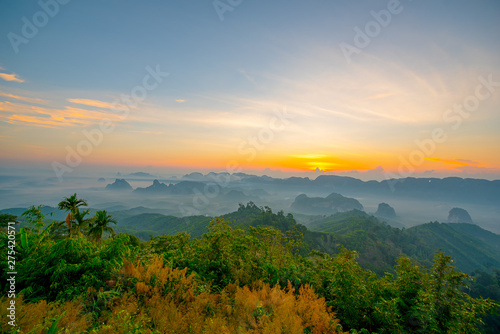 Beautiful mountain range with sky blue and orange light of the sun through the clouds in the sky, Background sky during Sunrise with fog on mountain, Abundant lush forest-Image © DSM