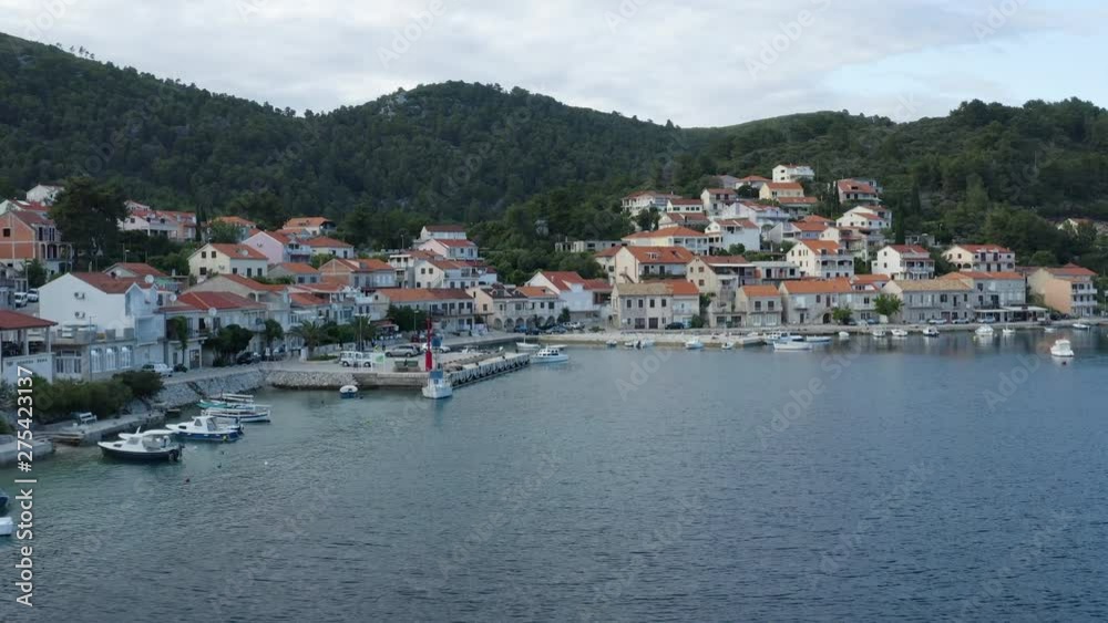 Aerial establishing shot of Brna village, cove of Korcula island. Seaside traditional Croatian homes with calm warm waters Aerial establishing shot of Brna village, cove of Korcula island. Seaside traditional Croatian homes with calm warm waters