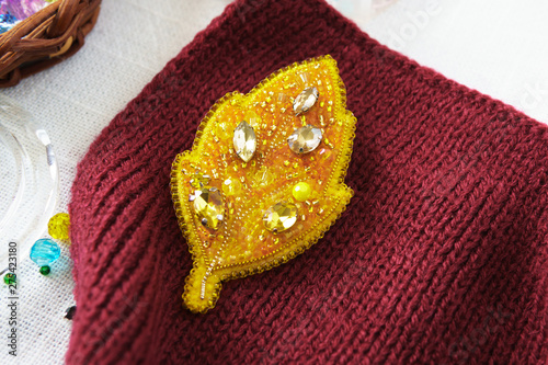 Brooch yellow leaf autumn beaded on the table on white background
