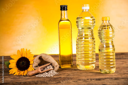 Sunflower oil in a bottle and sunflower flowers and sunflower seeds in a sack photo