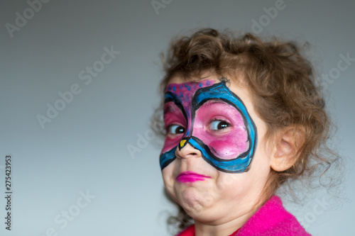 Isolated close up portrait of a five year old girl with a butterfly makeup costume
