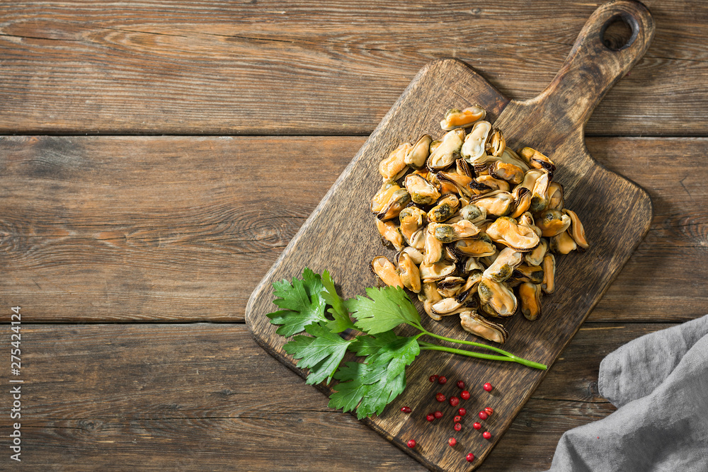 Fototapeta premium Mussel meat on a wooden Board on a wooden table. Rustic style