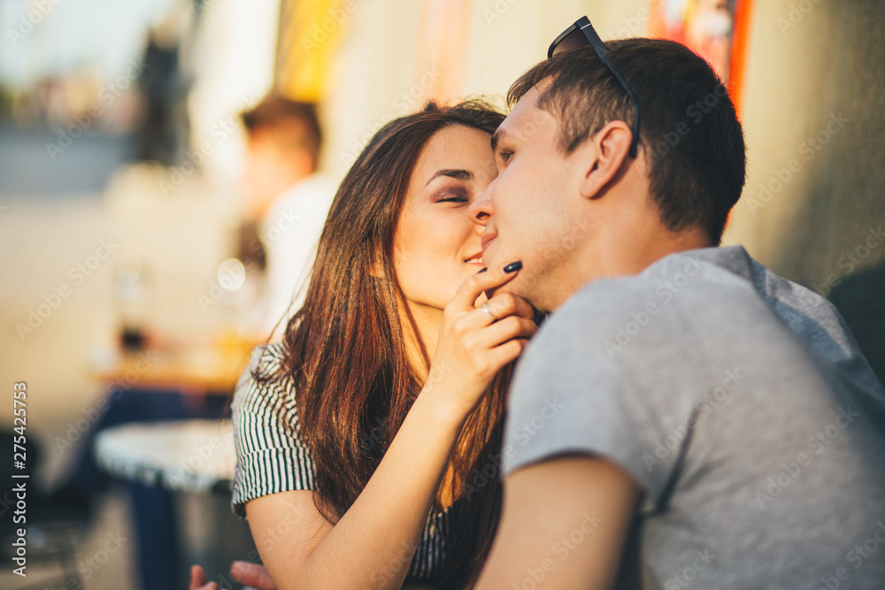 Happy young couple in love teenagers friends dressed in casual style kissing  in street cafe on sunset Stock Photo | Adobe Stock