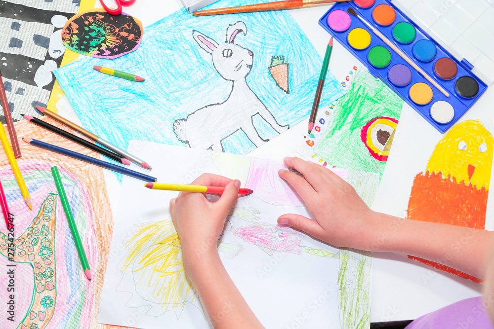 child's hands. Little left-handed child drawing with pencils. Top view, education painting, drawing concept. child's hands. Little left-handed child drawing with pencils. Top view, education painting, drawing concept.