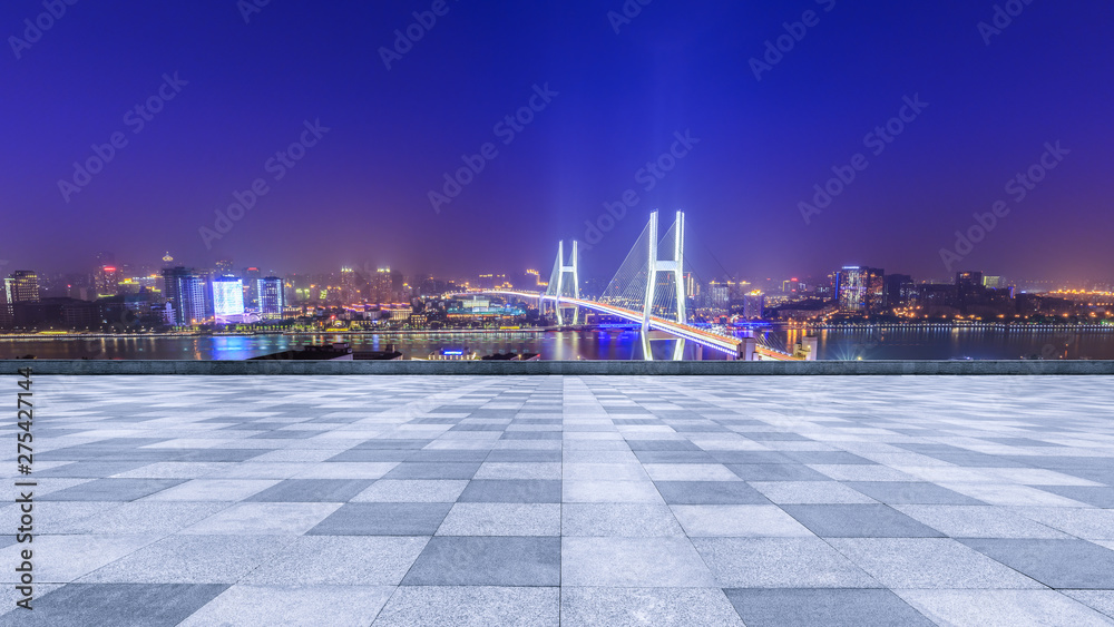 Empty square floor and bridge buildings at night in Shanghai,China