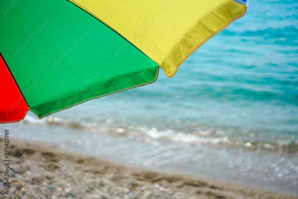 Colorful beach umbrella against sunny blue sky Colorful beach umbrella against sunny blue sky