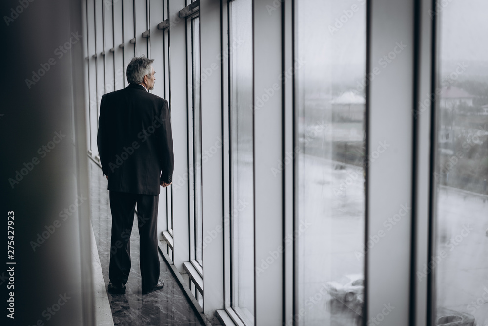 Fototapeta premium Serious elder man in Empty room. left without work and business. Credit, depression, ruin, bankrupt