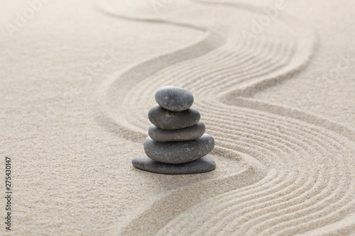 zen stones piled on raked sand with copy space for your text