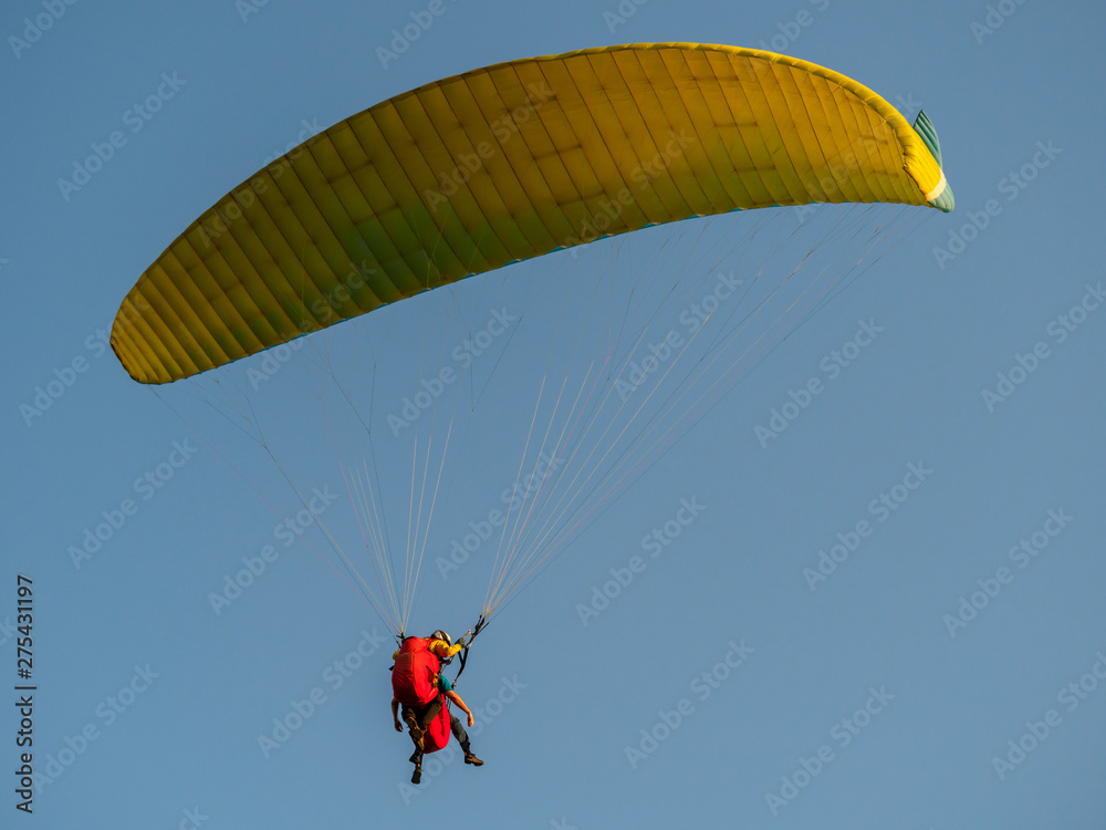 Paraglider with passanger flying in the blue sky. Paraglider with passanger flying in the blue sky.