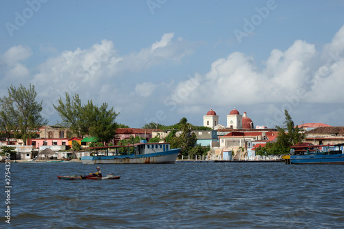 Cuba, Holguin area, the church and city of GIBARA from the sea where a fisherman stands in a very basic boat photo
