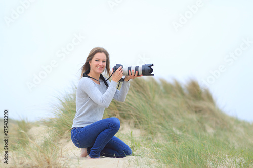 Young woman taking pictures at the beach