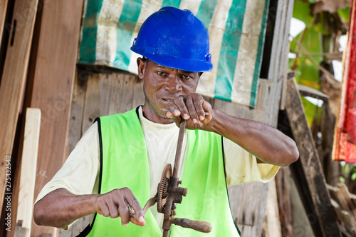 The carpenter in his workshop made with wood, is now turning a crank. photo