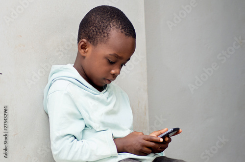 This child is playing a game  in the mobile phone.