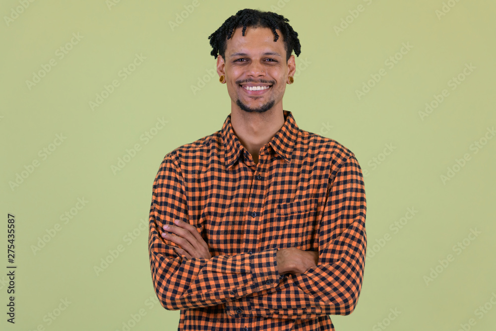 Fototapeta premium Happy young African man smiling with arms crossed