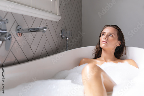 Thoughtful woman bathing in the bathtub in bathroom photo