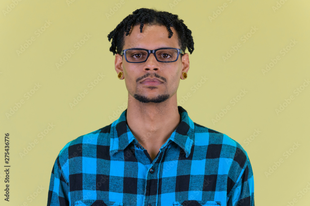 Fototapeta premium Face of young handsome African hipster man with eyeglasses