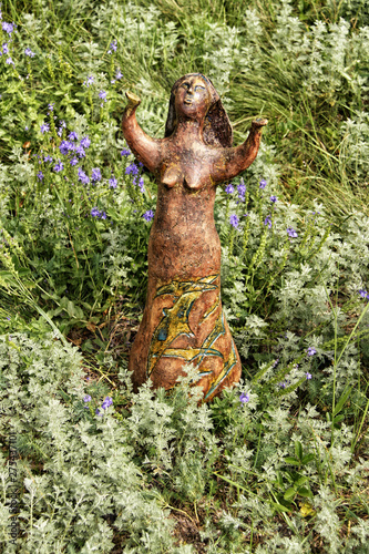 Small statue of the lady looking to the sky in the grass