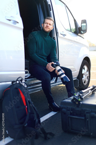 Professional photographer outside. Sit down in his van photo