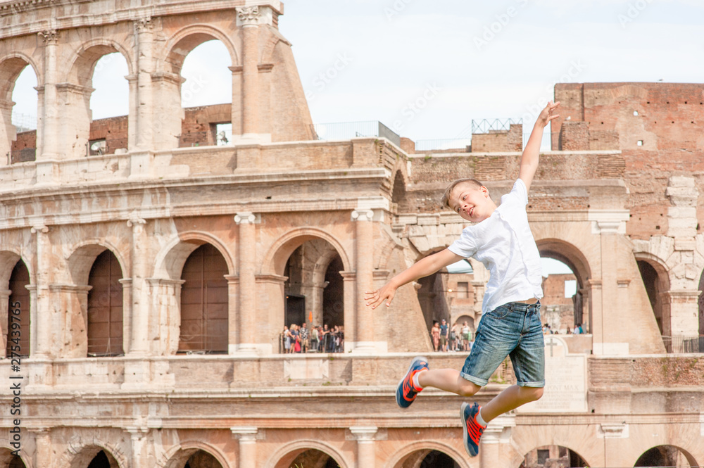 Very happy Young boy jumps at the coliseum in rome, Italy. Travel concept. Empty space for text
