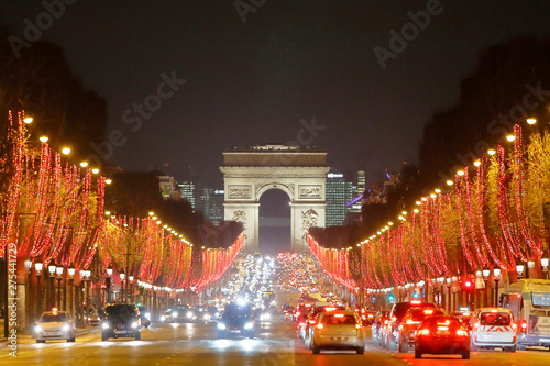 Paris, 8th arrondissement. Champs Elysees Avenue at night and Arc de Triomphe. Christmas illuminations 2018. Cars on the avenue.