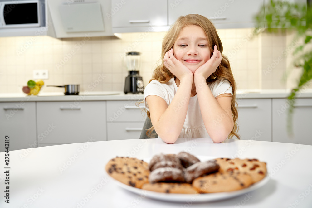 Front view of beautiful girl looking at tasty cookies