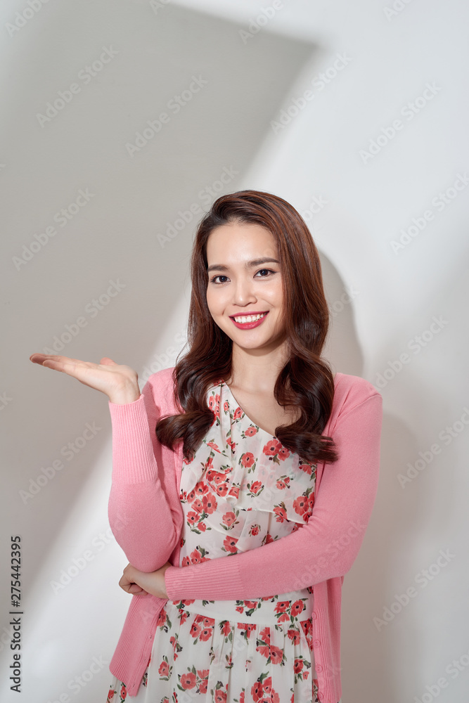 Beautiful young eurasian woman presenting your very exciting product. Isolated on white. Beautiful young eurasian woman presenting your very exciting product. Isolated on white.