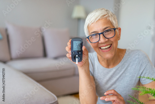 Concerned senior women doing blood sugar test at home. Lancet testing the blood glucose level of a person, diabetes. Diabetes concept and diabetes test photo