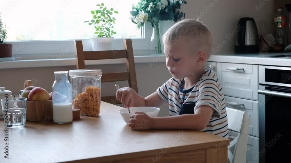 Cute boy 4 years old having breakfast cornflakes with milk at the table at home. Cute boy 4 years old having breakfast cornflakes with milk at the table at home.