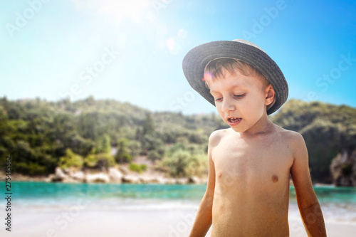 Small boy with summer hat and beach landscape 