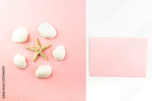 Flat lay top view Pink envelope, seashells on a pink background. Summer tropical vacation background. 
