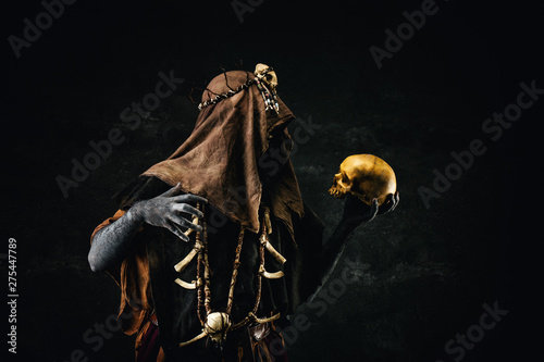 Portrait of a shaman holding a human skull photo