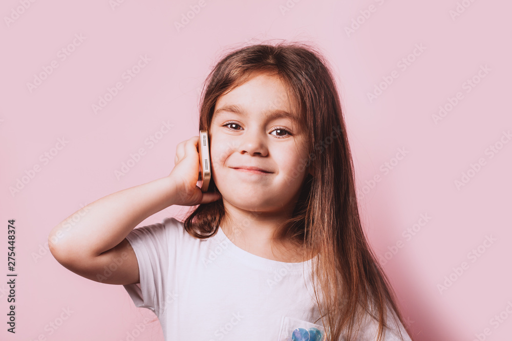 Happy little girl talking on telephone on pink background. Happy little girl talking on telephone on pink background.