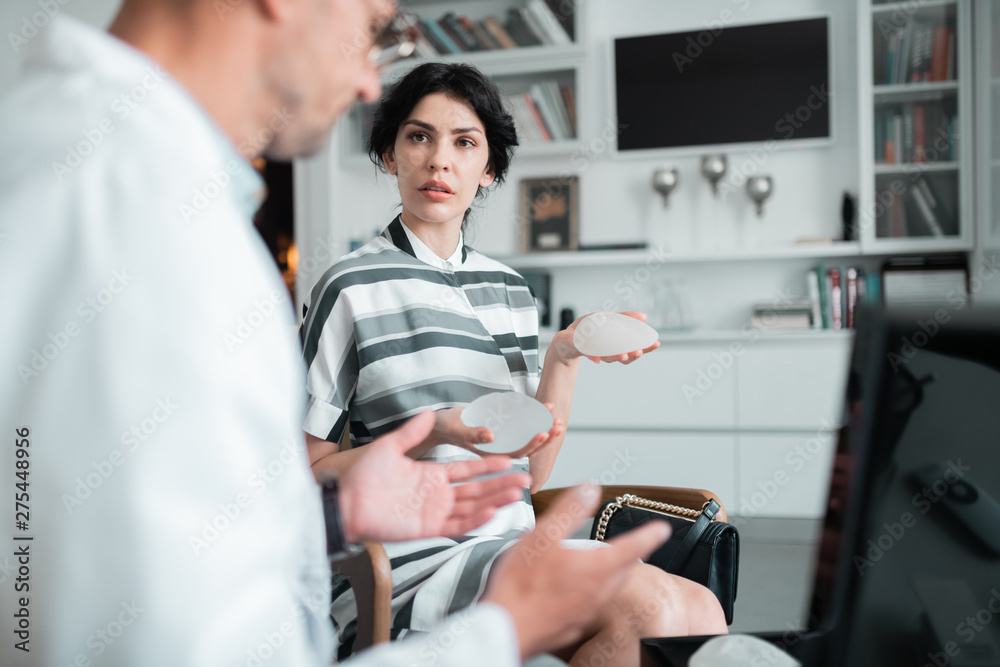 Obraz premium Client of plastic surgeon asking questions about implants