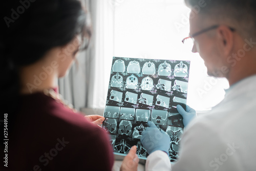 Plastic surgeon showing client her ultrasound of face photo