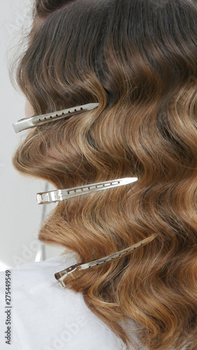 Silver hairdressers clips in wavy hair - close up 