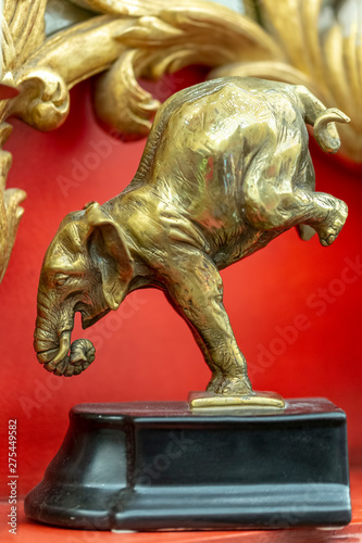 bronze statuette of an elephant in a interior red background