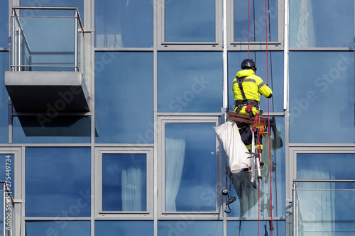 A man cleaning windows on a high rise building