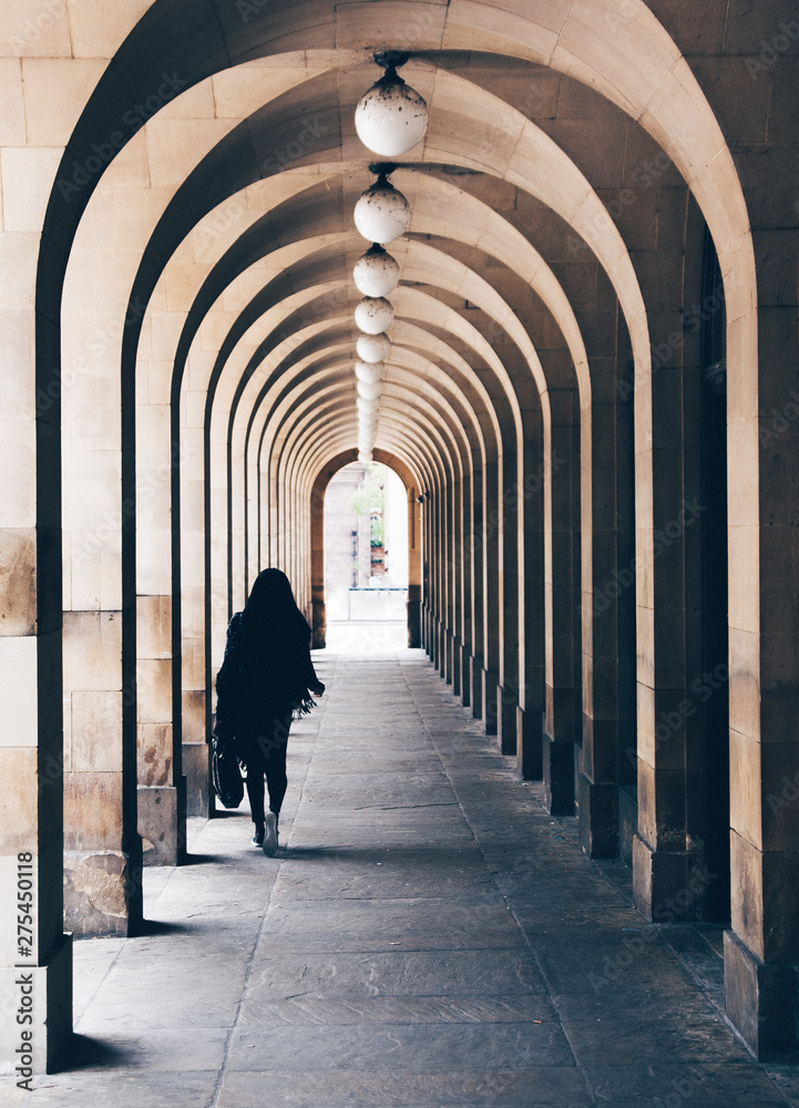 Woman walking in colonnade Woman walking in colonnade