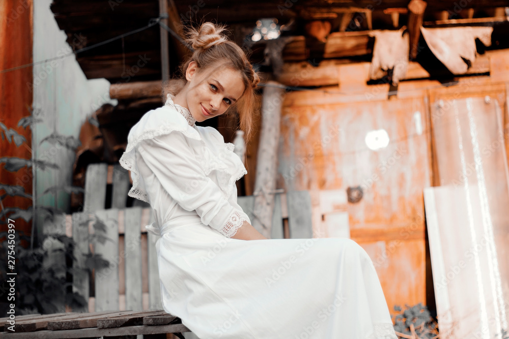 young girl in retro style in white dress sitting smiling emotion of joy in the village - obrazy, fototapety, plakaty 