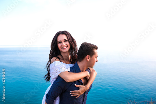 Romantic couple hugging ans smiling at sunset.