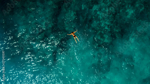 Young Woman Swimming in Beautiful Azure Ocean © ronedya