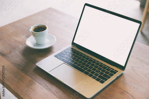 laptop and cup of coffee on wooden background.