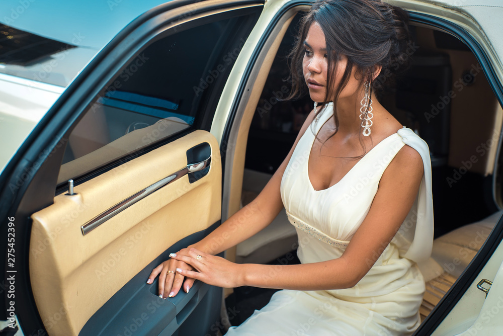 Young attractive VIP Woman getting out of limousine with door being open Young attractive VIP Woman getting out of limousine with door being open