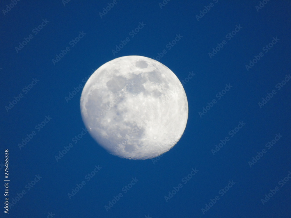 Genova, Italy - 06/15/2019: An amazing photography of the full moon over the city of Genova by night with a great clear and blue sky in the background and some stars. Genova, Italy - 06/15/2019: An amazing photography of the full moon over the city of Genova by night with a great clear and blue sky in the background and some stars.