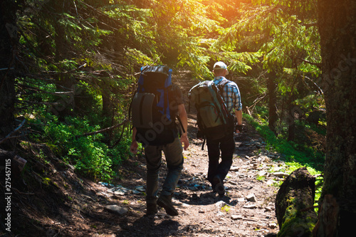 Two friends travel in the mountains with backpacks