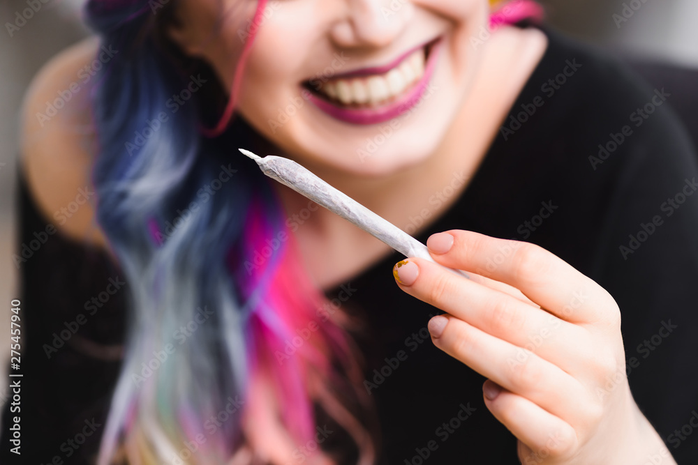 selective focus of joint with medical cannabis and cheerful girl selective focus of joint with medical cannabis and cheerful girl