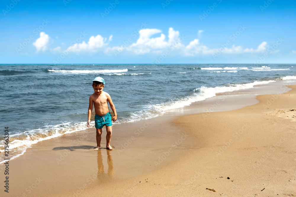Young boy on beach and summer landscape of sea. Free space for your decoration. 