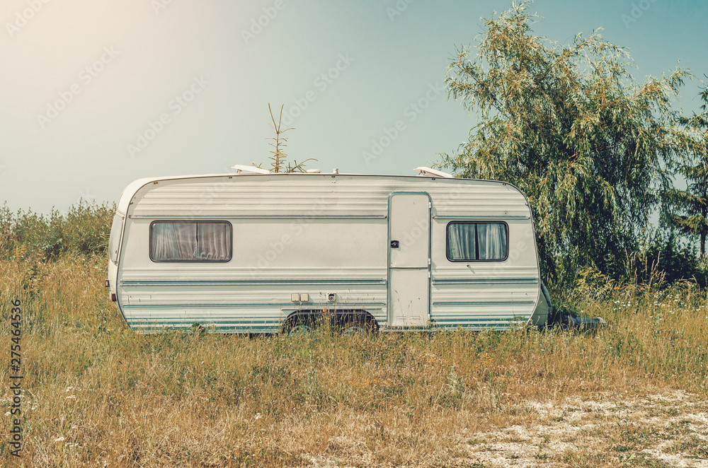 White trailer trailer house on wheels in the grass. Affordable Housing White trailer trailer house on wheels in the grass. Affordable Housing