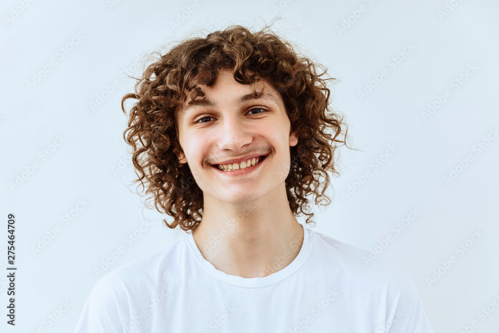 Curly guy portrait against white background. Laughter and joy emotions Curly guy portrait against white background. Laughter and joy emotions